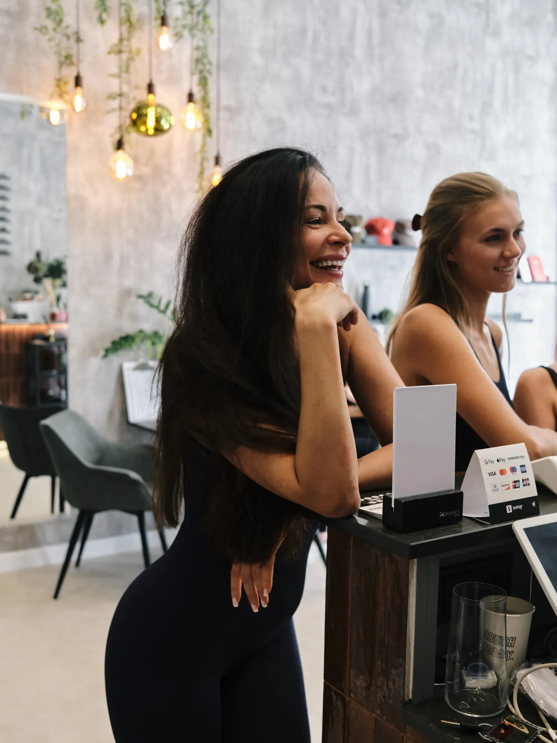 Zwei Gäste lachen an der Café-Theke