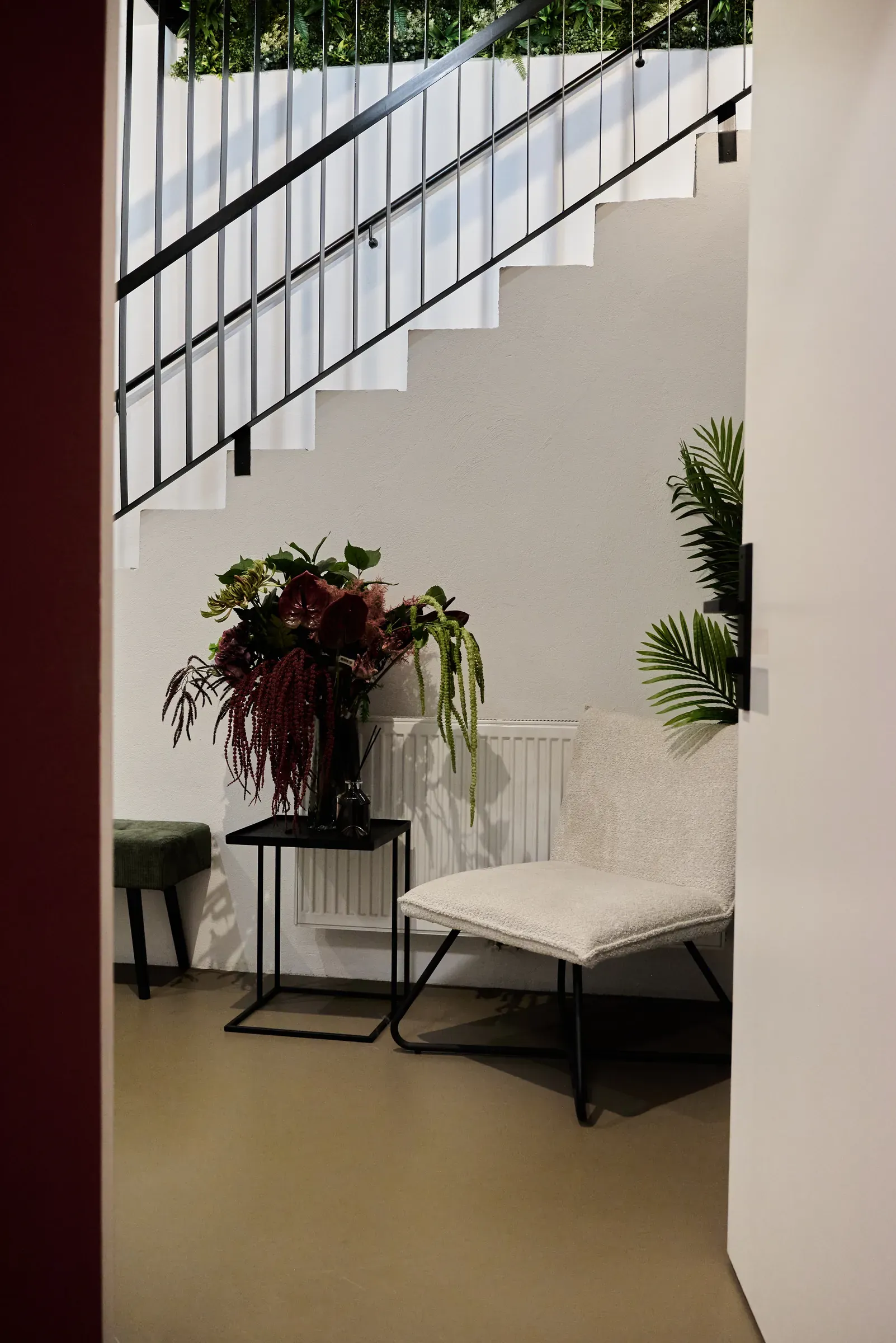 Sessel und Blumen unter der Treppe
